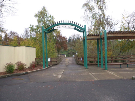 Archway and sign to Klineline Ponds – hard surface – benches – bridge over creek to ponds and amenities